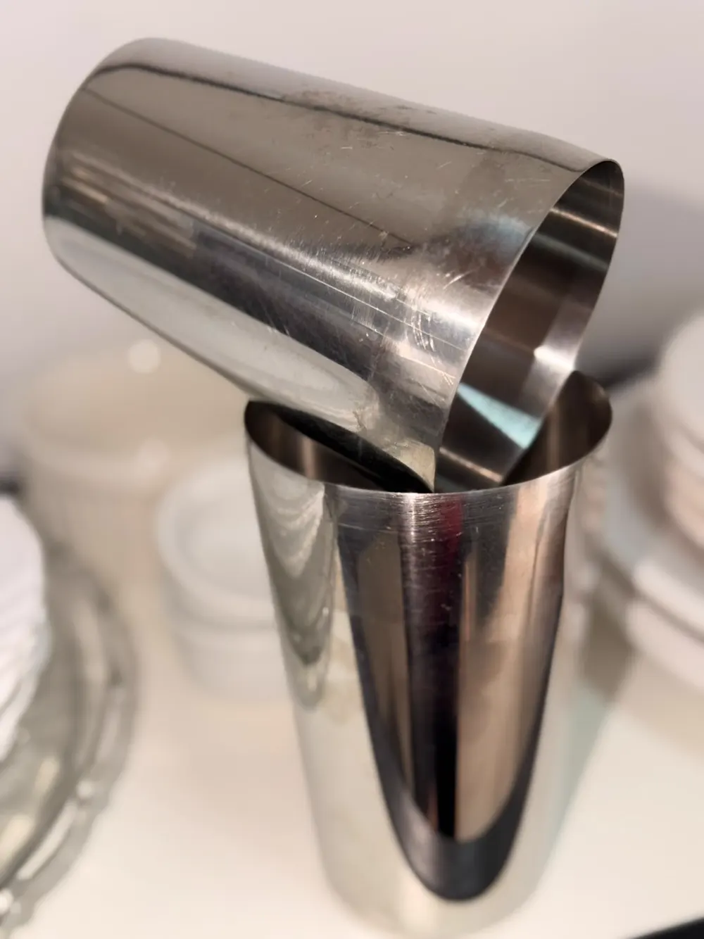 Coqueteleira de inox em dois copos para preparo de drinks no bar do evento