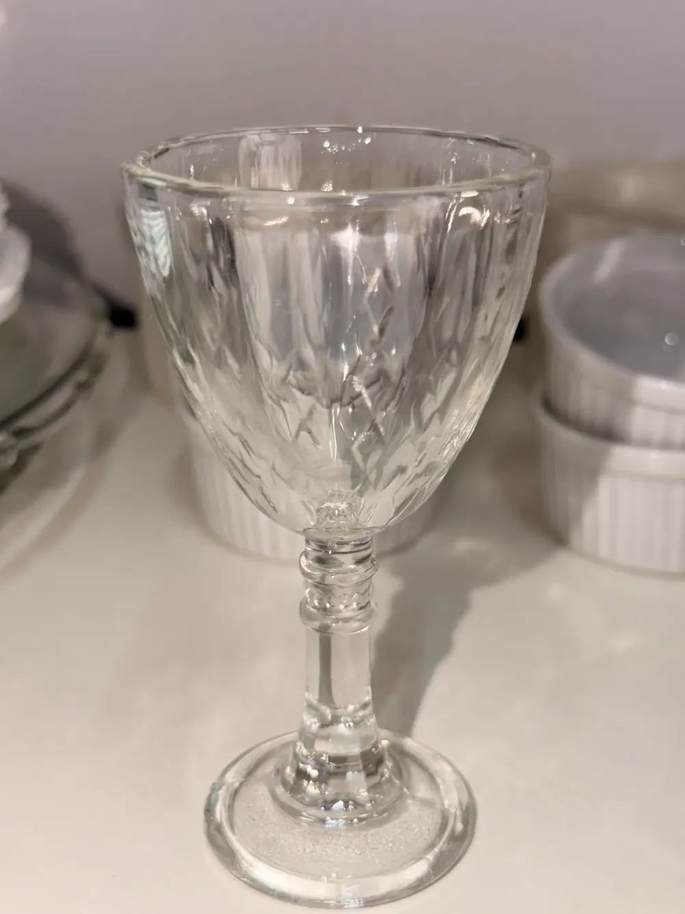 Taça de vidro transparente com bojo lavrado e haste trabalhada para locação em festas
