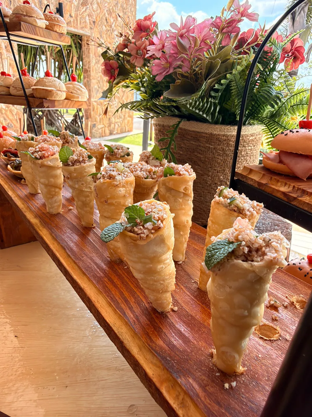 Cones de finger food com tabule alinhados sobre tábua de madeira